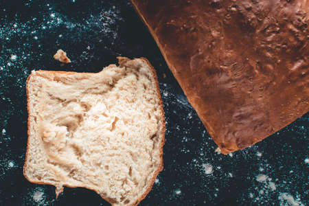 Freshly made white bread on a black wooden background.の写真素材