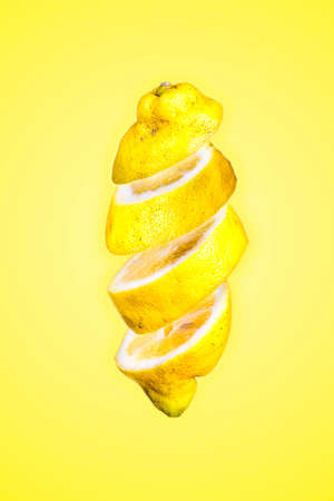 Image in suspension of a lemon cut with the yellow background.