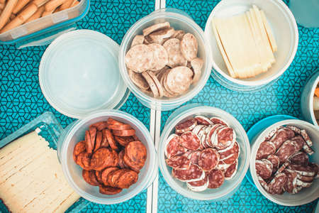 Sausage cut into pieces and potatoes for a picnic in the field.