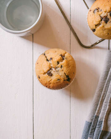 Homemade cupcake with pieces of chocolate on a wooden table.の写真素材