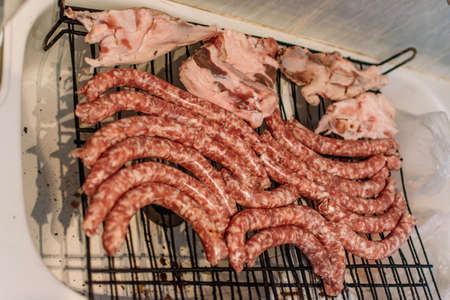Raw meat put on grills to cook on the coals.の写真素材