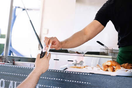 Food truck concept. Man paying for his takeaway food.の写真素材