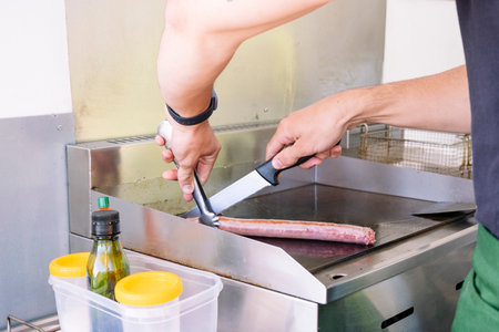 Food truck concept. Cook making a sausage on the grill.の写真素材