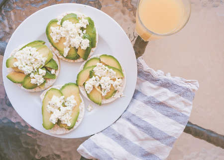 Puffed wheat toast with avocado and fresh cheese with olive oil and parsley.の写真素材
