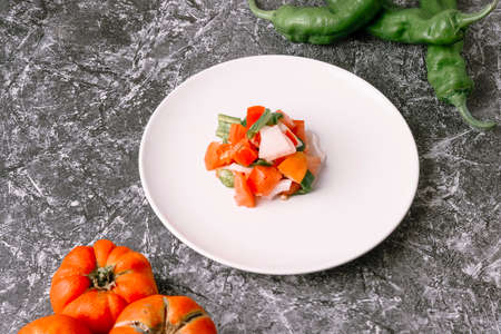 Mediterranean diet concept. Tomato, onion and green pepper mince on a white plate.の写真素材