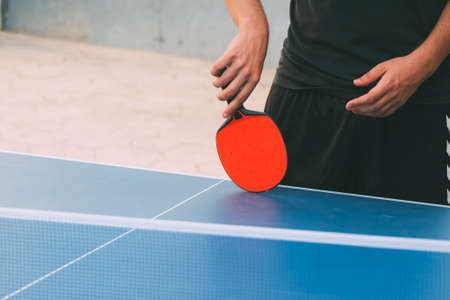 A person playing table tennis. Close-up of the table with the racket on the side.の写真素材