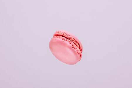 Strawberry macaron suspended in the air with purple background.の写真素材
