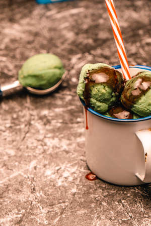 Scoops of green ice cream with an ice cream scoop.の写真素材
