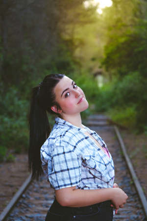 Teenager standing on some abandoned train tracks.の写真素材