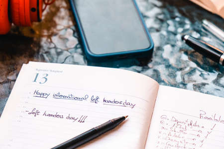 Happy lefties day! Party marked on the calendar with red headphones on a table.