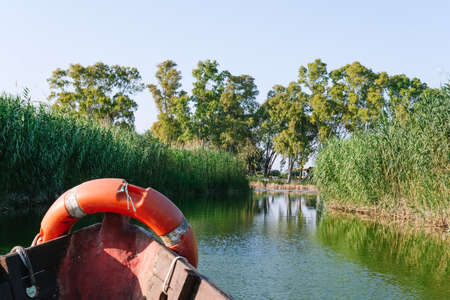 Fishing boat plying the canals of a lagoon.の写真素材