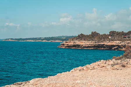 Rocky shore with a small cliff in the sea.の写真素材