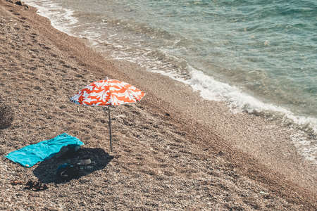 Orange umbrella placed on the shore of the beach.の写真素材