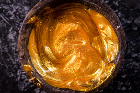 Golden ointment in a bowl on a gray marble background.の写真素材