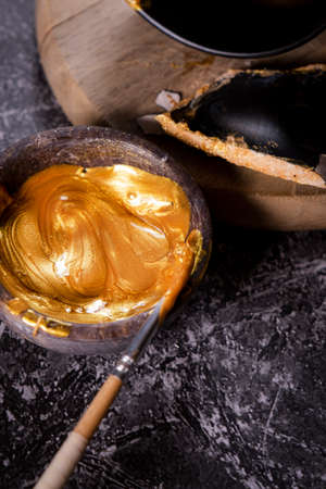 Bowl with a golden ointment for the art of kintsugi.の写真素材