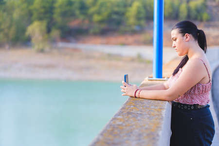 Teenager sitting looking at smartphone.の写真素材