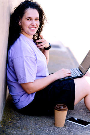Digital nomad girl with curly brunette hair.