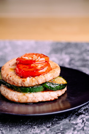 Burger plate with grilled vegetables on a black plate.の写真素材