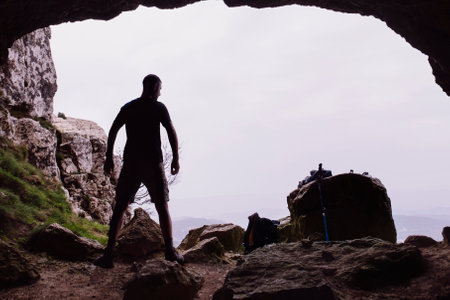 Silhouette of a man with victorious arms in a cave.の写真素材