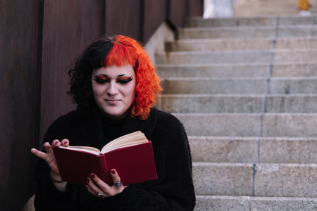 Transgender girl reading a book on the stairs.の写真素材