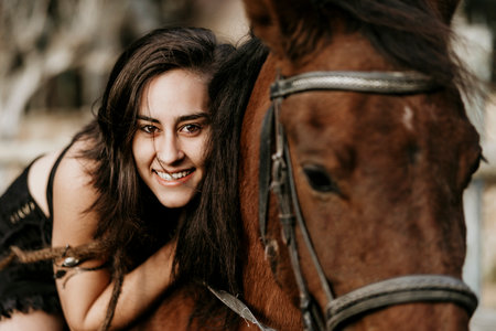 Amazon girl in black dress hugging her horse.の写真素材