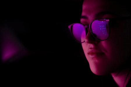 Close-up of a girl with glasses looking at a screenの写真素材
