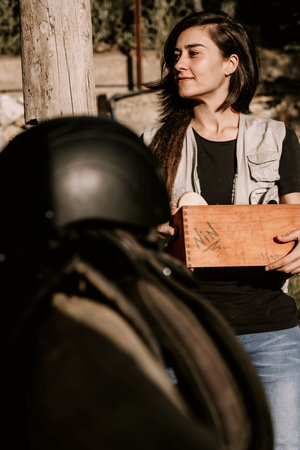 Dark-haired girl preparing the utensils for horse care.の写真素材