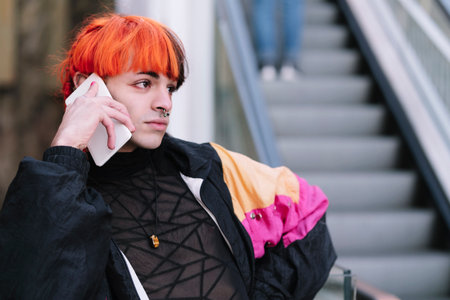Boy with painted hair looking at the phoneの写真素材