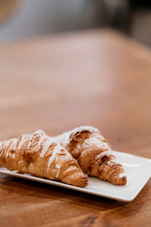 Close-up of two chocolate-filled croissants on a wooden table.の写真素材