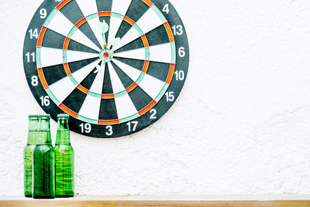 Three beer bottles next to a target with a white background