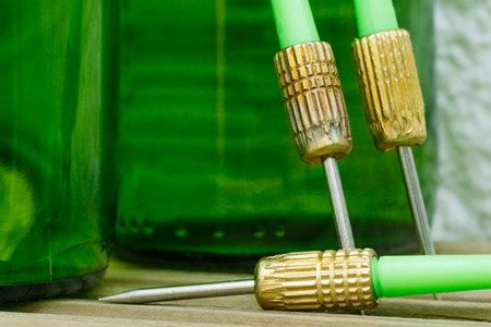 Green darts from a dartboard resting on beer bottlesの写真素材