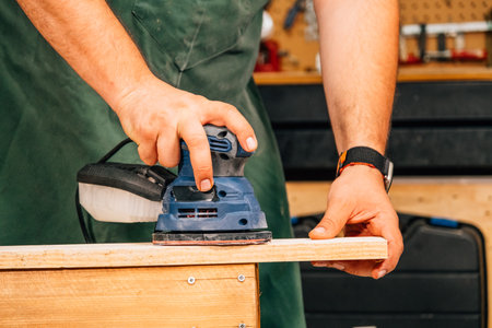 A person sanding with an electric sander.の写真素材
