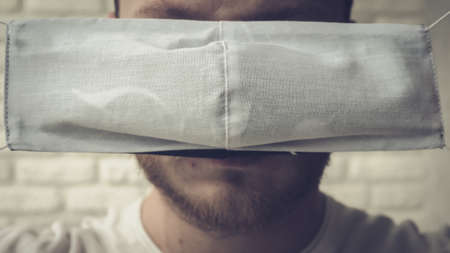 man covers his face with a medical mask.の写真素材