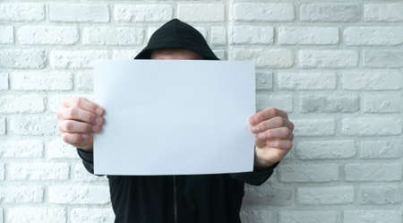 white piece of paper for text in the hands of a guyの写真素材