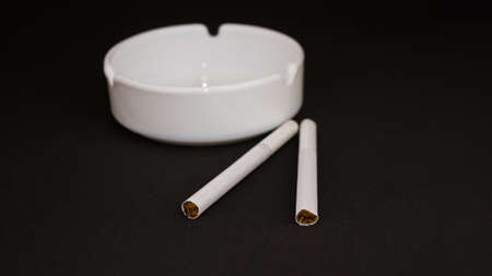 two cigarettes with an ashtray on a black backgroundの写真素材