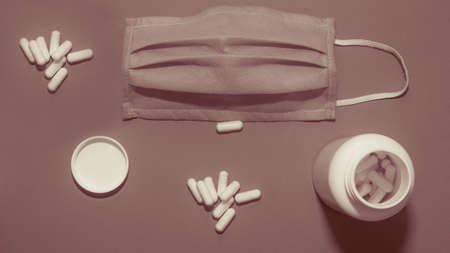 Tablets in a plastic jar, top view, medical mask for the face, protective against viral complaints, close-up.の写真素材