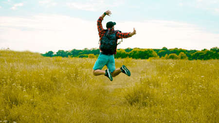 A cheerful guy, a man in a jump in nature, a happy person, a tourist rejoices in life, a lifestyle of a young guy.の写真素材