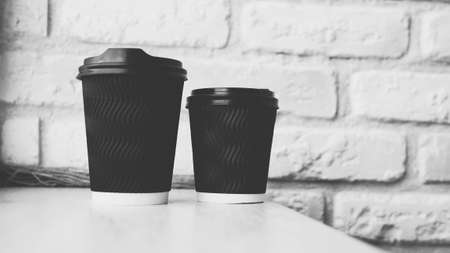 A glass of cappuccino against a brick wall, black and white photo, close-up, aromatic coffee on the bar, black grain coffee in a glass covered with a lid.の写真素材