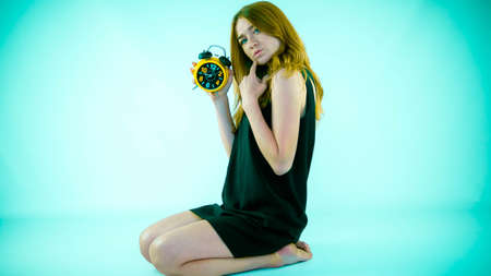Young and beautiful girl in a dress, a retro watch in her hands, close-up.