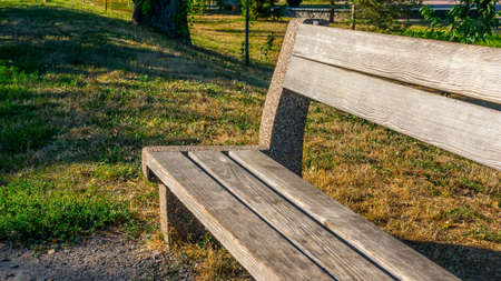 Park bench, wooden on green grass, close-up.A seat for relaxing in a public place.