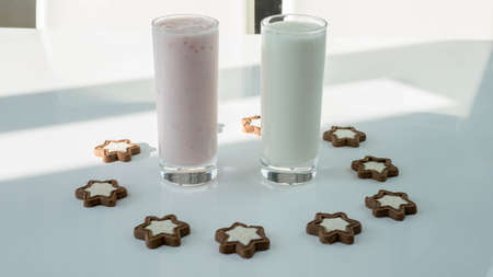 Yogurt in glass with figured cookies in the form of stars, dairy product on a white background, fruit yogurt close-up.の写真素材