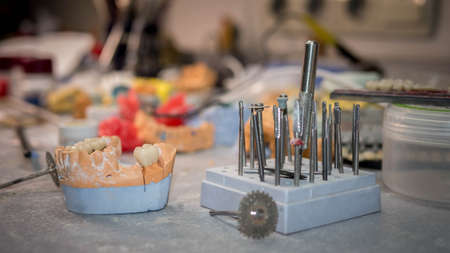 Ceramic crown of a tooth on a plaster model of teeth, the work of a dental technician, tools for...