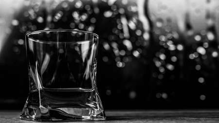 Glass with an alcoholic drink black and white picture. Whiskey in a glass close-up.の写真素材