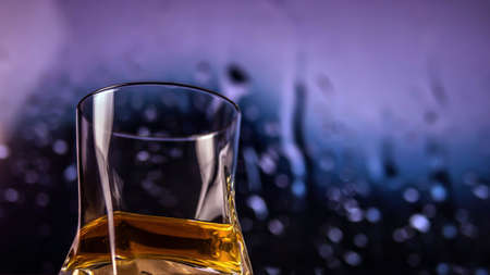 Whiskey in a glass on a colorful background with bokeh effect, Alcoholic drink in a glass, close-upの写真素材