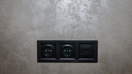 Electrical outlet on a gray Venetian wall. Antenna for tv in the form of a socket, antenna socket