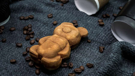Background from coffee and pastries teddy bear, aromatic coffee with pastries, coffee beans on silk cloth, cappuccino in a cozy atmosphere.の写真素材