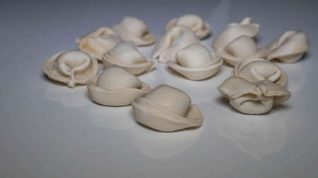 Raw dumplings on a white kitchen table top, dumplings close-up