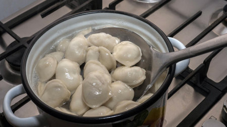 Cook the dumplings in a saucepan, stir the dumplings with a spoon in boiling water, home cooking.の写真素材