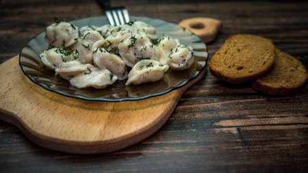 Dumplings in a plate decorated with herbs, dumplings on a wooden tray with a forkの写真素材