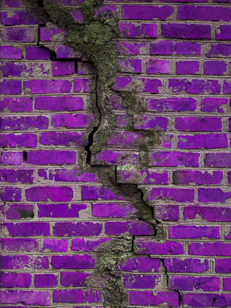 Texture of a brick wall with cracks in purple. Destroyed ancient wall violet. Brick background copy space.の写真素材